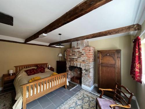 a bedroom with a bed and a brick fireplace at The Fish Loft in Tewkesbury