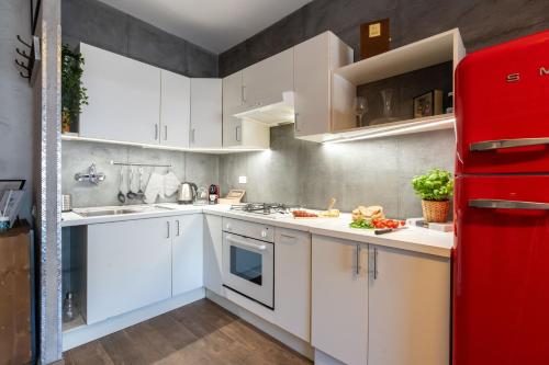 a kitchen with white cabinets and a red refrigerator at Casa del Sole - Free Parking in Rome