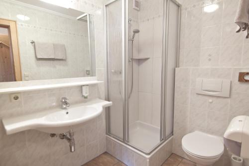 ein Bad mit einer Dusche, einem Waschbecken und einem WC in der Unterkunft Gasthof Sonne in Matrei in Osttirol