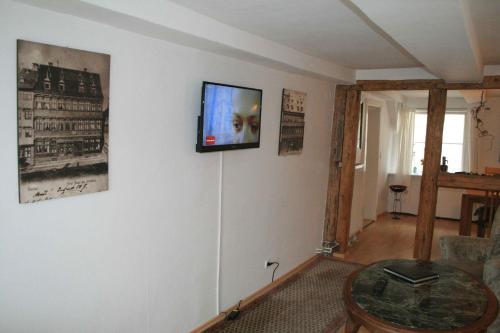 sala de estar con TV en la pared en Fachwerkferienhaus Helmbrecht, en Goslar