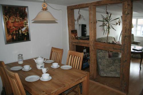 comedor con mesa de madera y sillas en Fachwerkferienhaus Helmbrecht, en Goslar