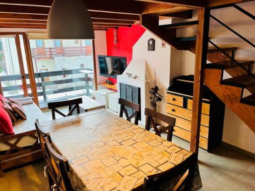 een eetkamer met een houten tafel en een kamer met een trap bij alojamiento en Bariloche CIPRES in Bariloche