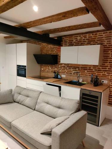 ein Wohnzimmer mit einem Sofa und einer Küche in der Unterkunft Appartement Capitole hypercentre in Toulouse