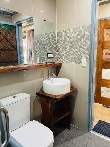 a bathroom with a sink and a toilet at White Beach Front and Cottages in Buruanga
