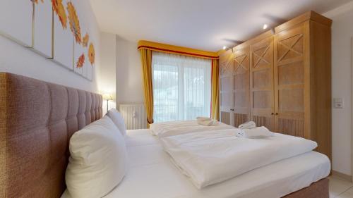 ビンツにあるFeWo direkt am Strand mit Südbalkon, Villa Freia 13, Binzのベッドルーム1室(白いシーツ付きのベッド1台、窓付)