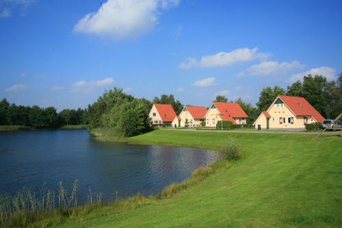 a row of houses next to a body of water at Summio Villapark Akenveen in Tynaarlo