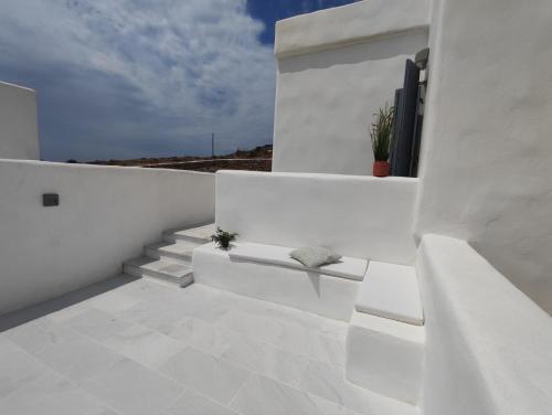 a white balcony with stairs and a potted plant at Krotiri View Paros in Krotiri