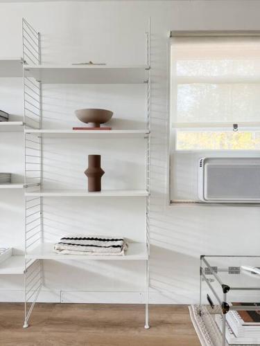 ein weißes Regal in einer Küche mit einer Mikrowelle in der Unterkunft Luxury Poconos Home Near Skiing, Lakes, & Waterparks in Tobyhanna