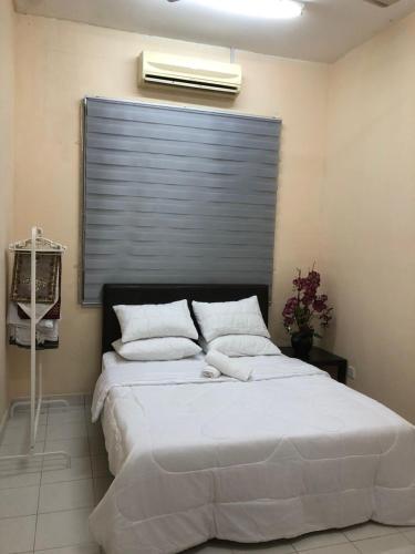a bedroom with a bed with a air conditioner above it at Azaliza Homestay in Ayer Keroh