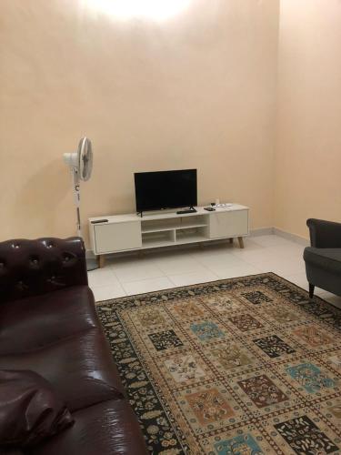 a living room with a couch and a flat screen tv at Azaliza Homestay in Ayer Keroh