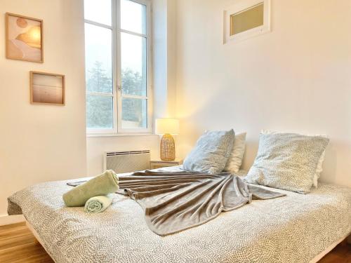 un lit dans une chambre blanche avec une fenêtre dans l'établissement LA PASSERELLE 1D - Quartier Gare - Wifi, à Quimper