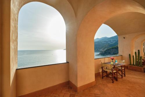 a room with a table and a view of the ocean at Hotel Botanico San Lazzaro in Maiori