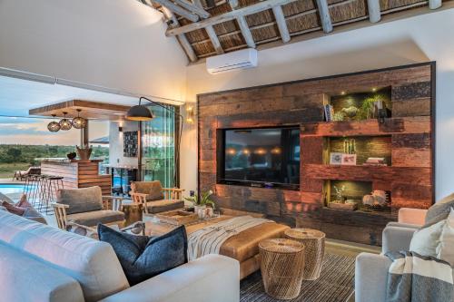 a living room with a fireplace and a tv at Marula Sunrise Lodge, Mjejane Private Game Reserve in Hectorspruit