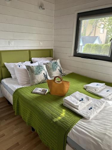 a bed with towels on it in a room at Balfala - komfortowe parterowe domki nad morzem z klimatyzacją in Ostrowo