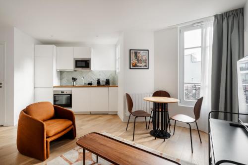 a living room with a chair and a table at Emilie Homes - Clichy in Clichy