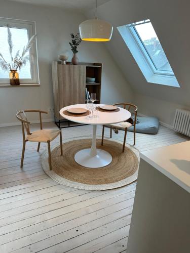 uma sala de jantar com uma mesa e duas cadeiras em Cozy City Apartment Daun - Ferienwohnung - EIFEL The Natural Home em Daun
