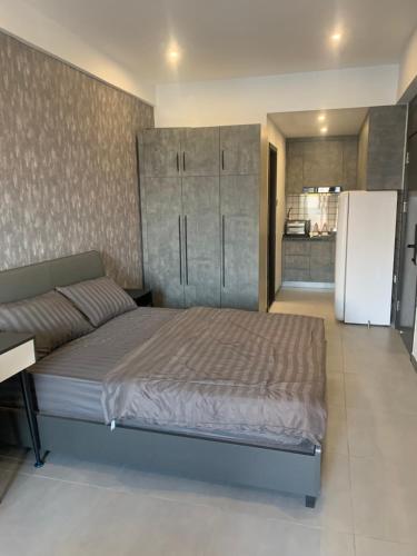 a bedroom with a large bed and a refrigerator at Cheaper But Biggest Studio Wit Gyms & Pools! Central in Phnom Penh