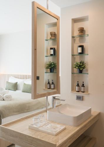 a bathroom with a sink and a mirror and a bed at Niranapa Boutique Resort in Kata Beach