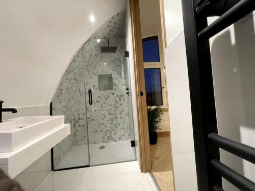 Ore的住宿－Contemporary Detached Eco House，带淋浴和盥洗盆的白色浴室