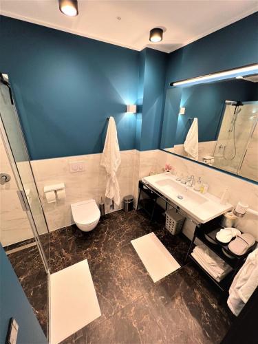 a bathroom with a sink and a toilet and a mirror at Villa Lettonia in Jūrmala