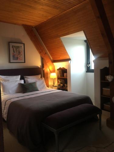 東姆的住宿－chambre de madel，一间卧室设有一张带木制天花板的大床