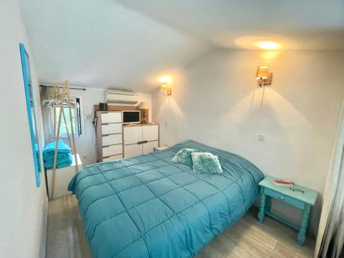 - une chambre avec un lit bleu et une table dans l'établissement Villa Hameaux du soleil, à Porticcio
