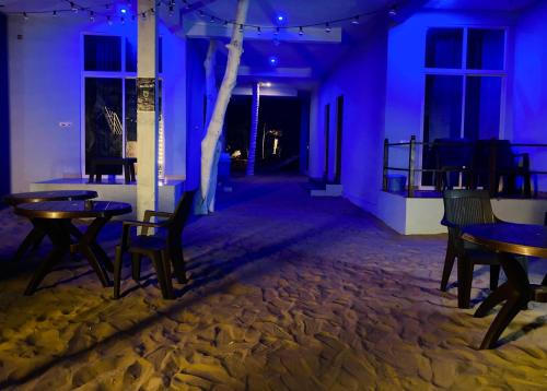 a room with tables and chairs and purple lights at Oceanic Stay And Restaurant Gokarna in Gokarn
