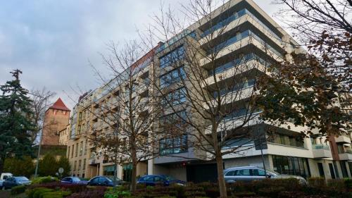 a large building with cars parked in front of it at Castle Apartments - Queen in Oświęcim