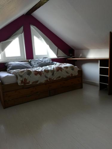 - un lit dans une chambre avec 2 fenêtres dans l'établissement Maison de ville au calme, à Bonneville