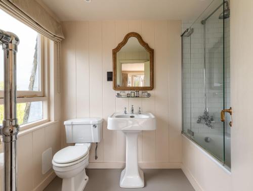 a bathroom with a toilet and a sink and a mirror at The Lookout Rye in Rye