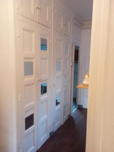 a room with white paneling and a wall with doors at Appartement hyper centre 1 lorient Jardin clos in Lorient