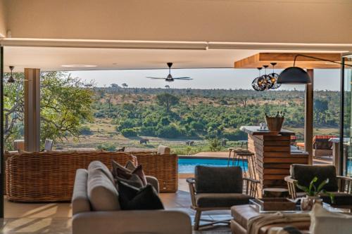 a living room with a view of a pool at Marula Sunrise Lodge, Mjejane Private Game Reserve in Hectorspruit