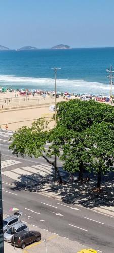 vistas a una playa con coches aparcados en la calle en Apartamento lateral mar en Río de Janeiro