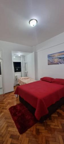 Un dormitorio con una cama con una manta roja. en Apartamento lateral mar en Río de Janeiro