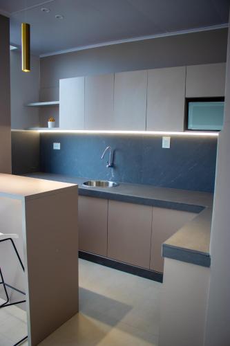 a kitchen with white cabinets and a sink at Hotel Amazonas Suite , suite lujosa in Nueva Loja