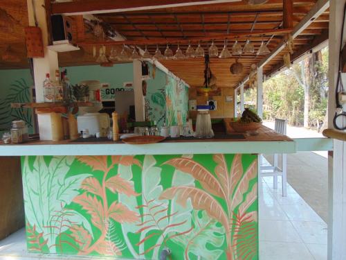 a kitchen with a counter with a colorful wall at Ings Garden in Gili Air
