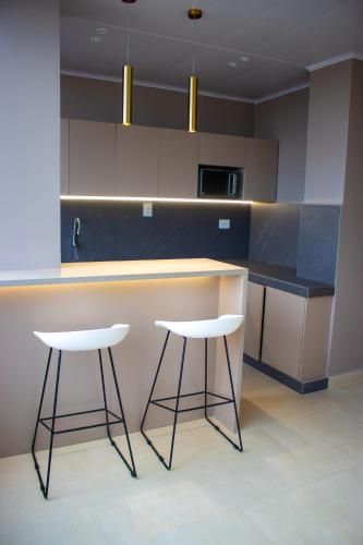 una cocina con 2 taburetes y una barra en Hotel Amazonas Suite , suite lujosa en Nueva Loja