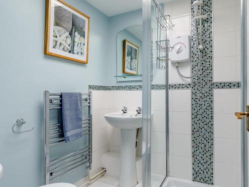 a white bathroom with a shower and a sink at 3 Bed in Brixham BX007 in Brixham