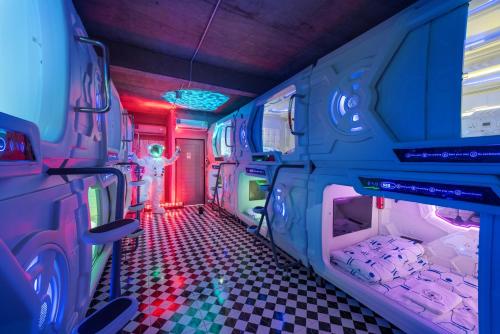 a room with a bus with a room with red lights at Space Station Hostel in Ban Don Muang