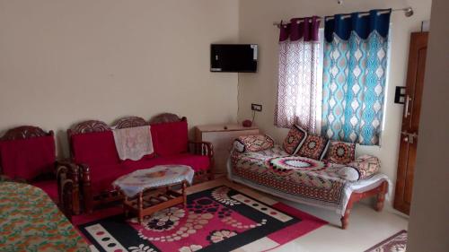 a living room with a couch and a chair at K K homestay in Madikeri