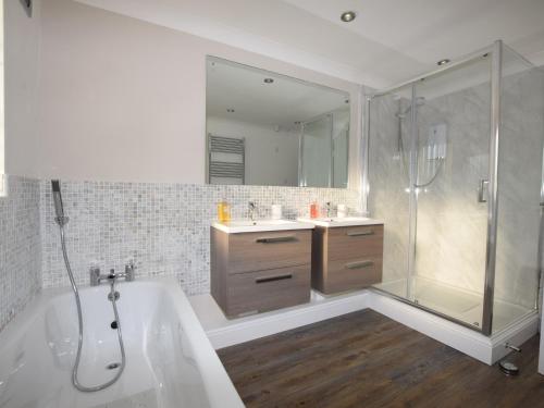 a bathroom with a tub and a shower and a sink at 3 Bed in Fakenham 56661 in Whissonsett