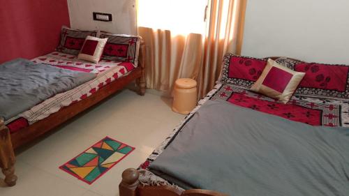a bedroom with two twin beds and a rug at K K homestay in Madikeri