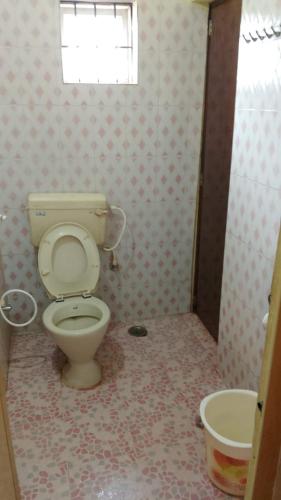 La salle de bains est pourvue de toilettes et d'un lavabo. dans l'établissement K K homestay, à Madikeri