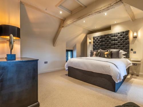 una camera da letto con un grande letto con una grande testiera di 1 Bed in Moreton-in-Marsh 56829 a Moreton in Marsh