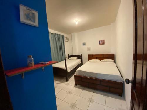 1 dormitorio con 2 camas y pared azul en Apartment near Malecon and Flavio Reyes Av MANTA, en Manta