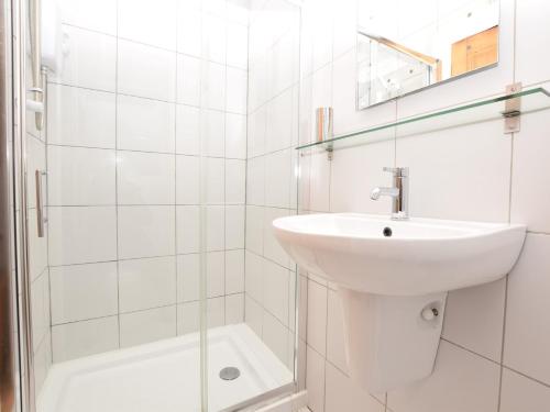 a white bathroom with a sink and a shower at 1 Bed in Nr Bamburgh CN002 in Lucker