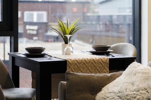 a table with two bowls on it in front of a window at Brand New Studio Apartment in Sheffield in Sheffield