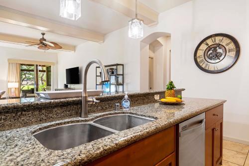 a kitchen with a sink and a clock on the wall at Mauna Lani Fairways 302 in Waikoloa