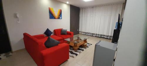 ein Wohnzimmer mit zwei roten Sofas und einem Tisch in der Unterkunft At Freddy's with free transport from JKIA in Nairobi