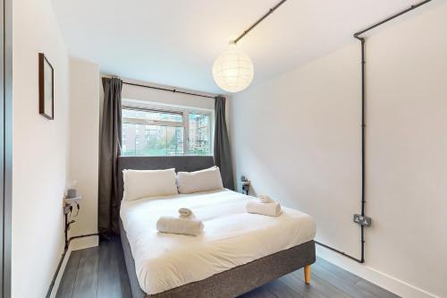 a bedroom with a bed with two towels on it at Stunning 1 BD apartment for 3 people in Hackney with Japanese-style bath in London